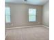 Carpeted bedroom with two windows and neutral paint at 2141 Spikerush Way, Buford, GA 30519