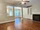 Open-concept living room showcasing hardwood floors, a fireplace, and seamless flow to the dining area and kitchen at 2141 Spikerush Way, Buford, GA 30519