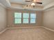 Main bedroom featuring tray ceiling, ceiling fan, and three windows that provide plenty of natural light at 2141 Spikerush Way, Buford, GA 30519
