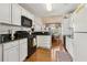 Bright kitchen with white cabinets, black countertops, and a black oven and microwave at 33 Evans Point Pt, Dallas, GA 30157