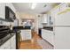 Well-lit kitchen featuring white cabinetry, black countertops, stainless steel appliances and wood flooring at 33 Evans Point Pt, Dallas, GA 30157