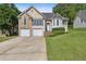 Inviting two-story home featuring a lush green lawn, dual garage, and elegant stone detailing at 33 Evans Pt, Dallas, GA 30157
