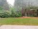 Spacious backyard featuring a lush lawn, mature trees, and a garden at 5850 Shiloh Woods Dr, Cumming, GA 30040