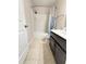 Bright bathroom features a shower and tub combo, with tile flooring and neutral paint colors at 5850 Shiloh Woods Dr, Cumming, GA 30040