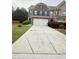 Charming brick home featuring a concrete driveway and landscaped front yard at 5850 Shiloh Woods Dr, Cumming, GA 30040