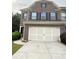 Two car garage with white doors and brown brick exterior at 5850 Shiloh Woods Dr, Cumming, GA 30040