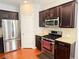 Well-equipped kitchen with stainless steel appliances, granite countertops, and dark wood cabinets at 5850 Shiloh Woods Dr, Cumming, GA 30040