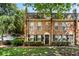 A brick townhome with a cozy, traditional facade surrounded by mature trees and manicured landscaping at 105 North River Dr # A, Atlanta, GA 30350