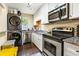 Modern kitchen with stainless steel appliances, granite countertops, and a stacked washer dryer at 105 North River Dr # A, Atlanta, GA 30350