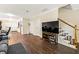 Open-concept living room with hardwood floors, staircase, and an abundance of natural light at 105 North River Dr # A, Atlanta, GA 30350
