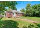 Large, grassy backyard with brick house and mature trees, perfect for outdoor activities at 1544 Brewer Sw Blvd, Atlanta, GA 30310