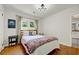 Well-lit bedroom with wood floors, a decorative blanket and view to the bathroom at 1544 Brewer Sw Blvd, Atlanta, GA 30310