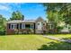 Charming brick home featuring a stone accent entrance, well-manicured lawn, and mature trees under a bright, sunny sky at 1544 Brewer Sw Blvd, Atlanta, GA 30310