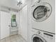 Bright laundry area with stacked washer/dryer, white walls, and window for natural light at 1544 Brewer Sw Blvd, Atlanta, GA 30310