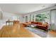Bright living room with hardwood floors, large window, stylish sofa, and seamless archway to the dining room at 1544 Brewer Sw Blvd, Atlanta, GA 30310