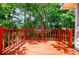 Wooden back porch with a bright red railing. Mature trees visible through and over the deck at 1716 Beacon Hill Ne Blvd, Atlanta, GA 30329