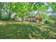 Large grassy backyard with trees, landscaping and rear view of the house with a deck at 1716 Beacon Hill Ne Blvd, Atlanta, GA 30329
