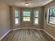 Bright dining area featuring three windows, wood-look flooring, and neutral paint for a modern look at 4433 Ford Pl, Snellville, GA 30039