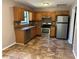Cozy kitchen featuring wood cabinets, stainless steel appliances, and tiled floors at 4433 Ford Pl, Snellville, GA 30039