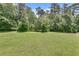 Spacious backyard with large green grass and line of trees at 543 Serene Waters Trl, Jonesboro, GA 30236