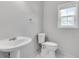 Bathroom featuring a pedestal sink, toilet, and window at 543 Serene Waters Trl, Jonesboro, GA 30236