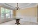 Elegant dining room features bright window, decorative chandelier, and white wainscoting at 543 Serene Waters Trl, Jonesboro, GA 30236