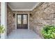 Elegant front porch with double doors, brick walls, and tile flooring at 543 Serene Waters Trl, Jonesboro, GA 30236