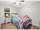 This bedroom features a ceiling fan, wood floors, and bright window views at 10650 Colony Glen Dr, Johns Creek, GA 30022