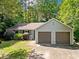 Charming single-story home with a two-car garage and lush landscaping in a serene, wooded setting at 10650 Colony Glen Dr, Johns Creek, GA 30022