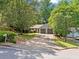 Single-story home with a two-car garage and long driveway nestled in a private, wooded setting at 10650 Colony Glen Dr, Johns Creek, GA 30022