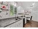 Bright kitchen features stainless steel sink, granite countertops, white cabinets, and a dining area at 10650 Colony Glen Dr, Johns Creek, GA 30022