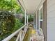 Cozy covered porch with white railing, comfortable bench, and serene views of the surrounding greenery at 10650 Colony Glen Dr, Johns Creek, GA 30022