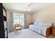 Inviting bedroom features large window, decorative throw pillows, and neutral wall color at 2577 Abbotts Glen Nw Dr, Acworth, GA 30101