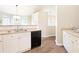 Functional kitchen with white cabinets, black appliances, and a view into the dining area at 2577 Abbotts Glen Nw Dr, Acworth, GA 30101
