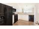 Well-lit kitchen with black appliances, white cabinets, and a view of the dining area at 2577 Abbotts Glen Nw Dr, Acworth, GA 30101