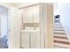 Convenient laundry room featuring white cabinetry and next to finished stairwell at 2577 Abbotts Glen Nw Dr, Acworth, GA 30101