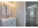 Bathroom vanity with white cabinets, chrome hardware, and view to living area at 3107 Hendrix Circle Sw, Covington, GA 30014