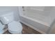 Bathroom showcasing a white toilet and bathtub with dark wood-look flooring at 3107 Hendrix Circle Sw, Covington, GA 30014