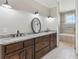 Bright bathroom with a double-sink vanity, granite countertop, and tiled shower-tub combination at 625 Henderson Mill Rd, Covington, GA 30014