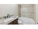 Bathroom with a granite countertop and a tiled shower-tub combo for a modern and clean aesthetic at 625 Henderson Mill Rd, Covington, GA 30014