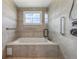 Modern bathroom features a tiled tub with glass shower and grab bars for safety at 625 Henderson Mill Rd, Covington, GA 30014