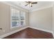 Bedroom featuring a ceiling fan, wood floors and a large window with neighborhood views at 625 Henderson Mill Rd, Covington, GA 30014