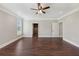 Spacious bedroom with trim and hardwood floors, featuring multiple doorways and windows, ceiling fan, and lighting at 625 Henderson Mill Rd, Covington, GA 30014