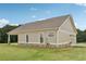 Tan house with stone accents, a side-entry garage, and a well-maintained lawn under a bright blue sky at 625 Henderson Mill Rd, Covington, GA 30014