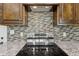 Close up of stainless steel stovetop and mosaic tile backsplash at 625 Henderson Mill Rd, Covington, GA 30014