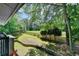 View of the backyard featuring a grass lawn, trees, and wood fence at 945 Tiber Cir, Alpharetta, GA 30022