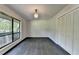 Empty bedroom with dark hardwood floors, a window with natural light and neutral walls and white closet doors at 945 Tiber Cir, Alpharetta, GA 30022