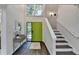Bright foyer with hardwood floors, a striking green door, staircase, and stylish console table at 945 Tiber Cir, Alpharetta, GA 30022