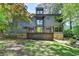 Stunning modern home with a wooden porch, stone accents, a green door, and surrounded by lush greenery at 945 Tiber Cir, Alpharetta, GA 30022