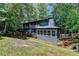 Back exterior view of home surrounded by tall mature trees and landscaping at 945 Tiber Cir, Alpharetta, GA 30022